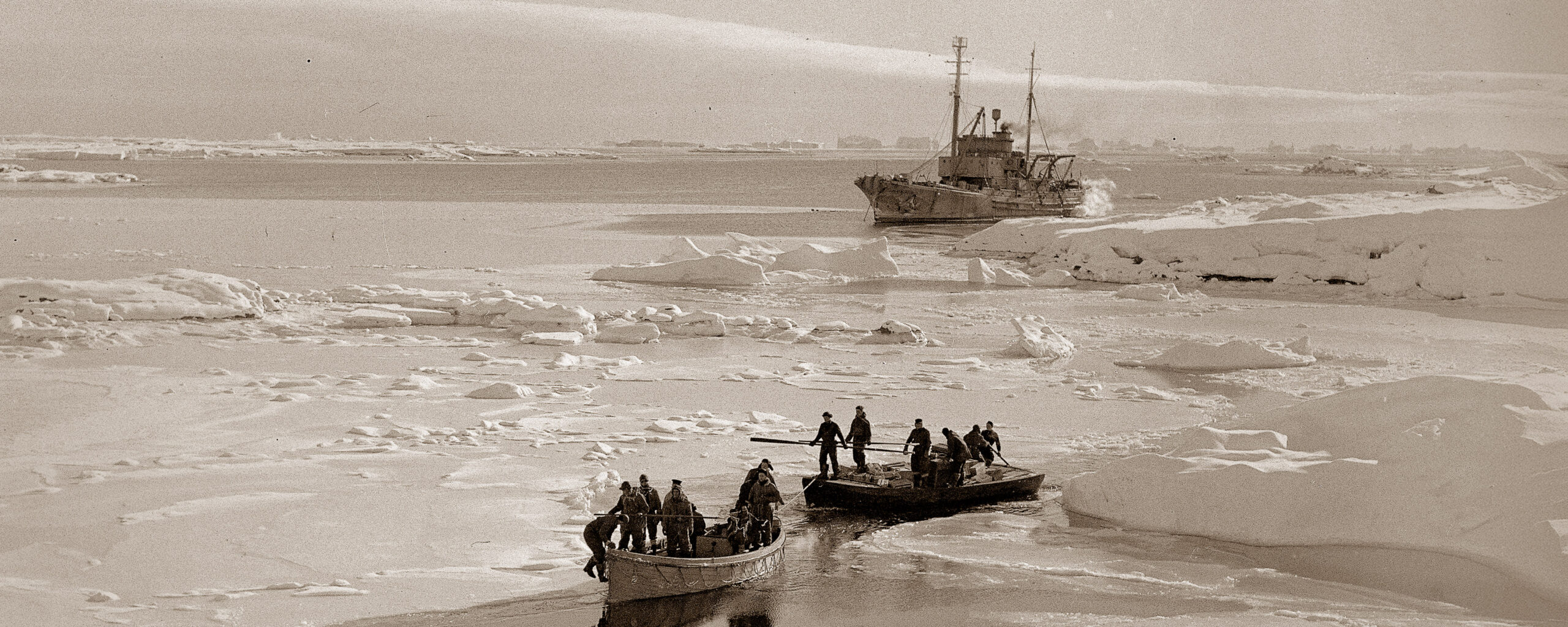 Off-loading stores. Personnel using 3 small boats to assist them in ferrying supplies ashore.Argentine Islands.