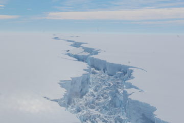 A plane flying over a snow covered slope