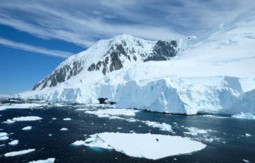 Ocean with floating sea ice, with a snowy mountain in the background