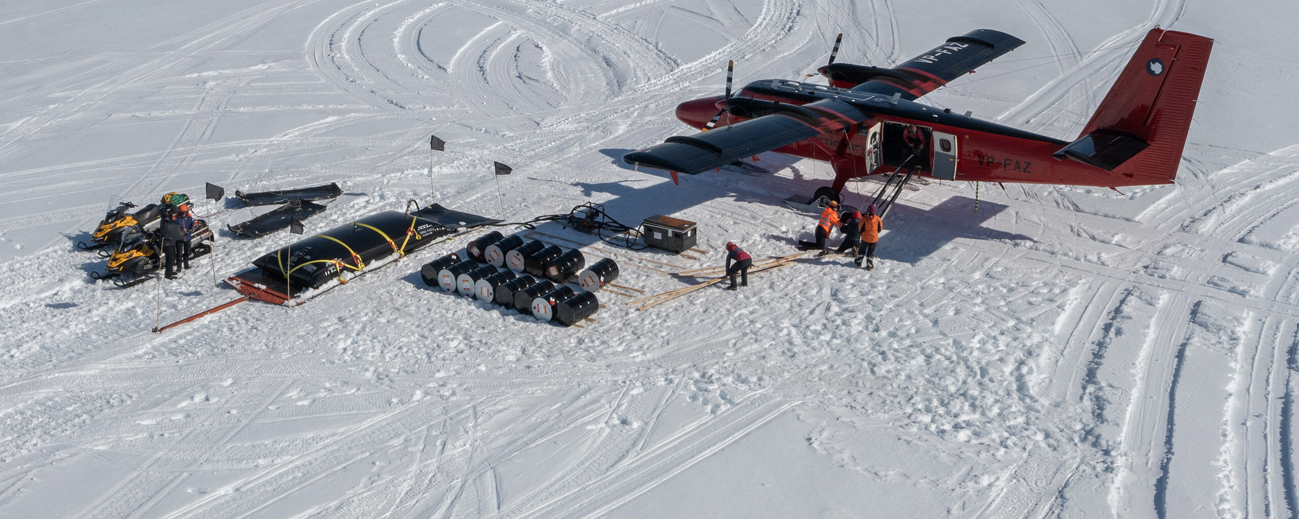 A BAS Twin Otter aircraft loading at a remote field location on the English Coast, Antarctica