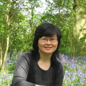 A woman standing in front of a tree.