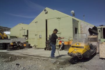 A group of people standing next to a truck.