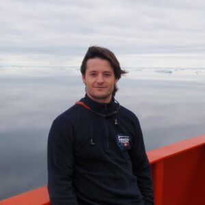 A man standing in front of a body of water.