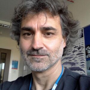 A man wearing glasses and smiling at the camera.