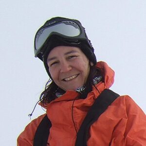 A person wearing a hat talking on a cell phone.