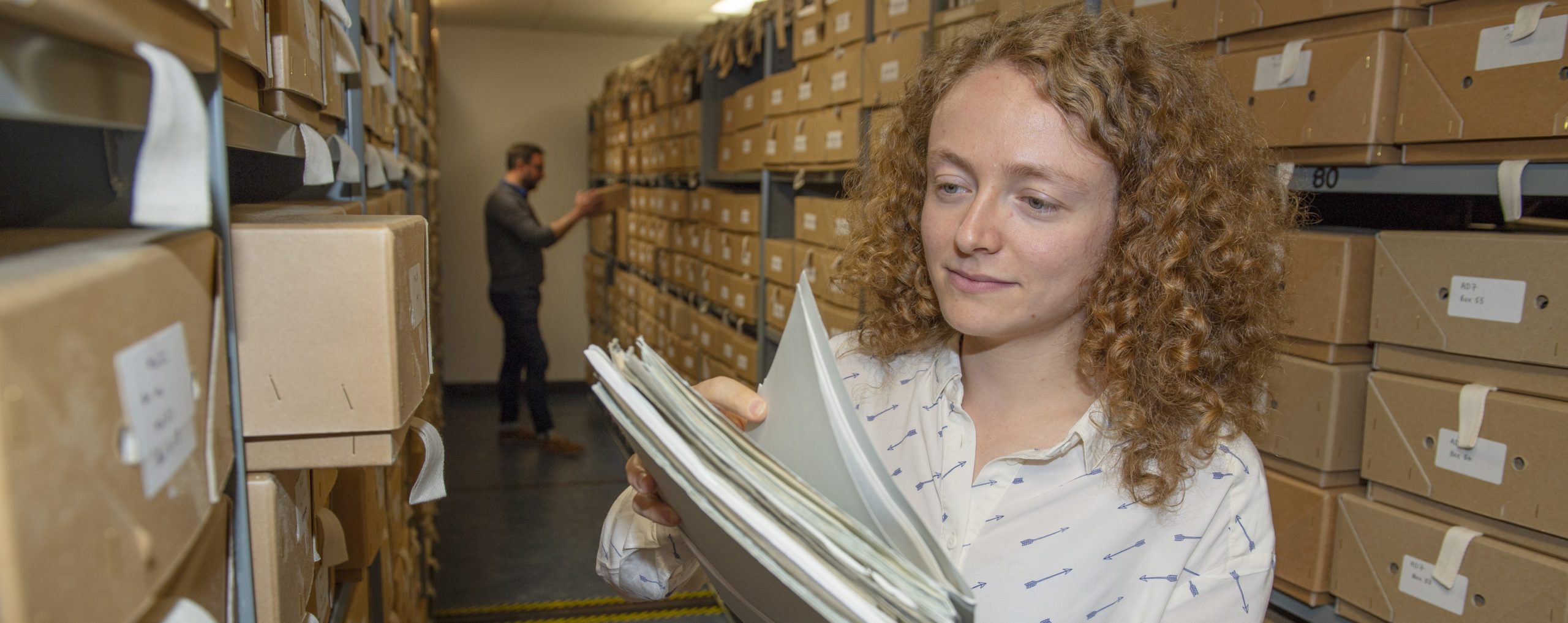 Alysa looking through valuable field party records in the archive at BAS Cambridge