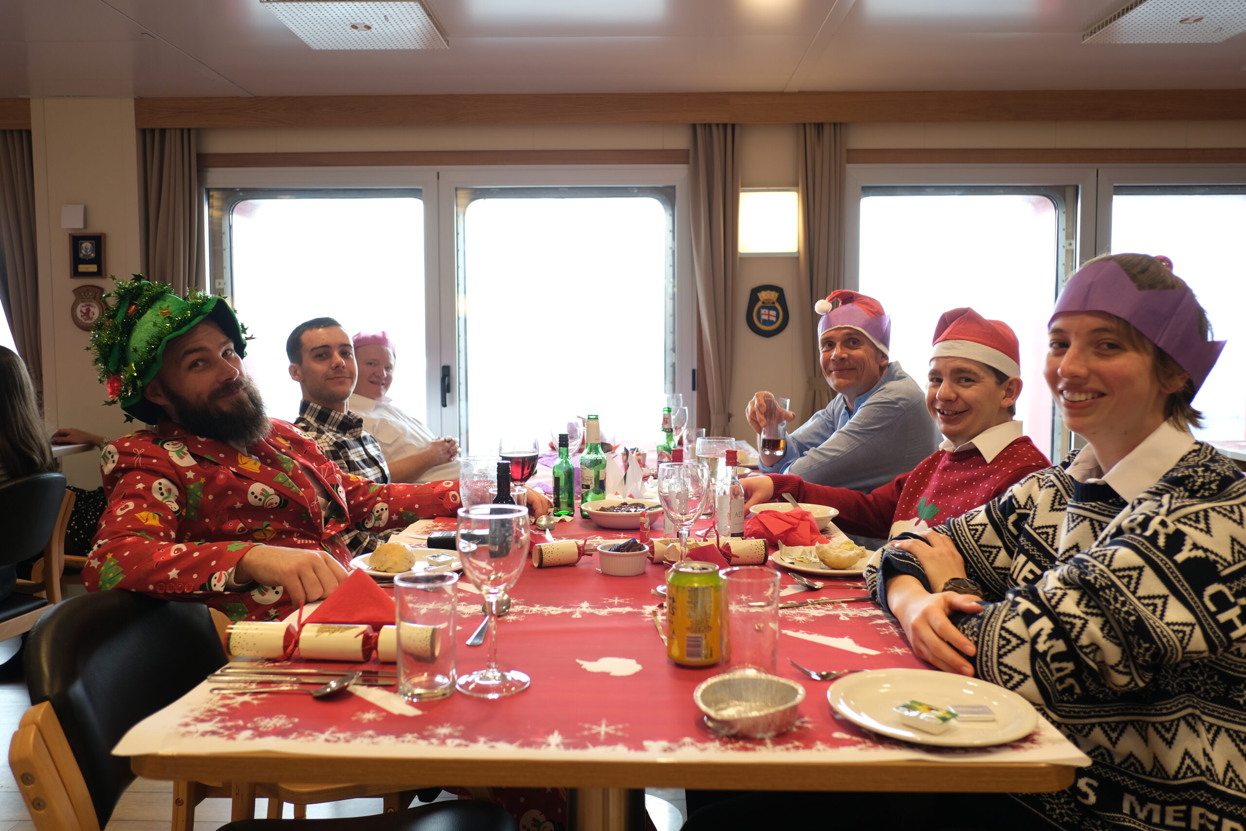 group of people sat round a table for a Christmas meal