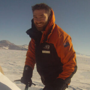 A man standing on top of a snow covered slope.