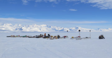 A group of people riding skis on top of a snow covered slope.