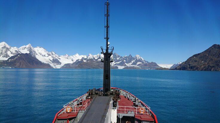 A boat on a body of water with a mountain in the background