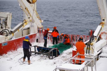 A group of people on a boat in the water.