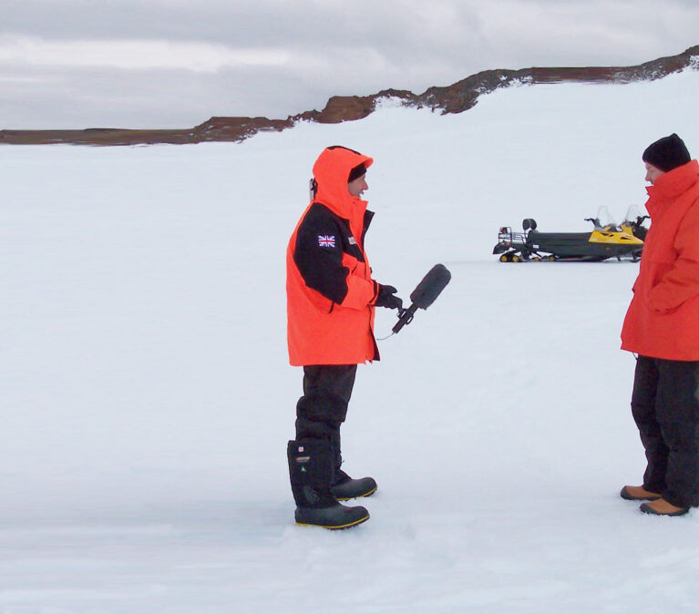 A film crew interviewing a man in an icy landscape