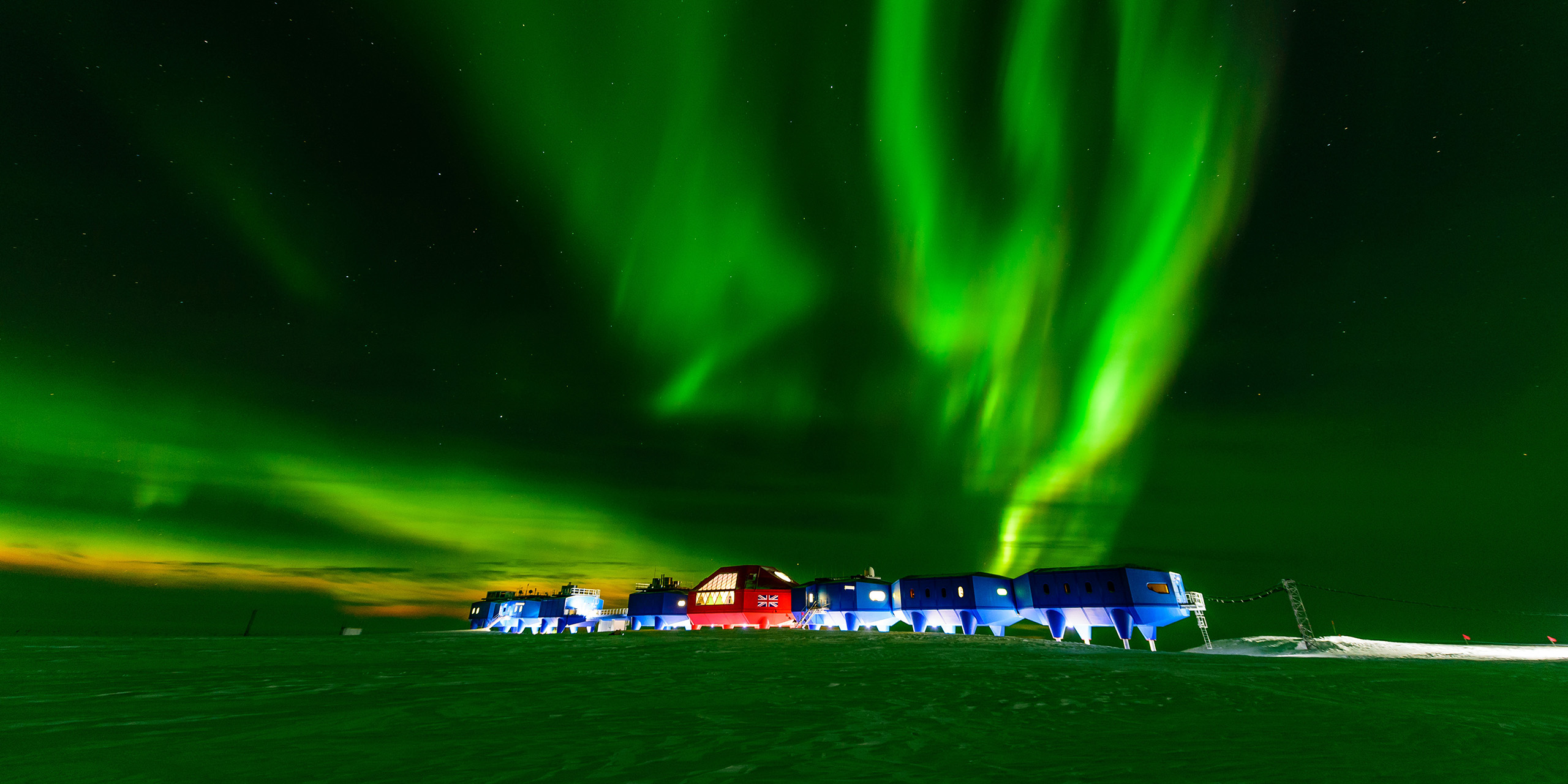 A green aurora illuminating Halley Research Station in Antarctica