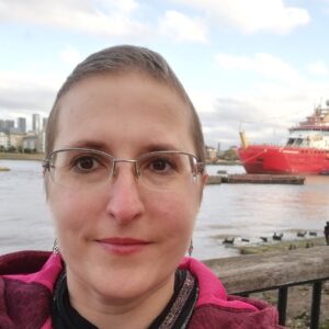 A person wearing glasses and smiling at the camera