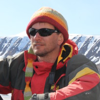 A person wearing a hat and sunglasses posing for the camera.