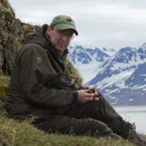 A man sitting on top of a snow covered mountain.