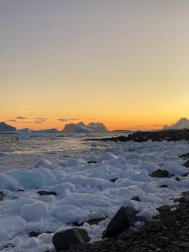 A snow covered landscape at sunset