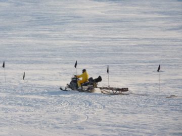 A group of people riding skis on top of a snow covered slope.