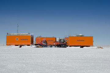 A large orange truck in a parking lot.