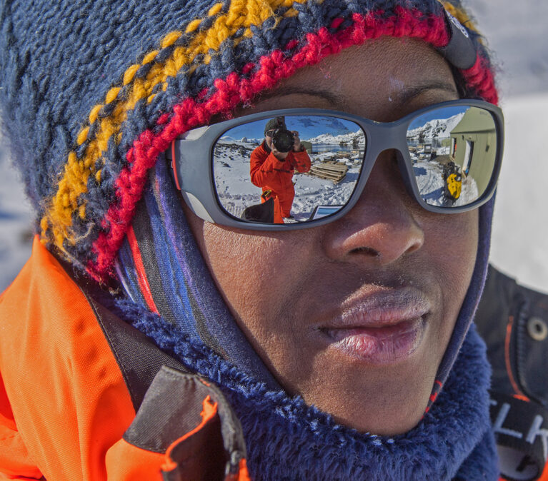 An engineer wearing sunglasses, wolly hat and hi-vis clothing