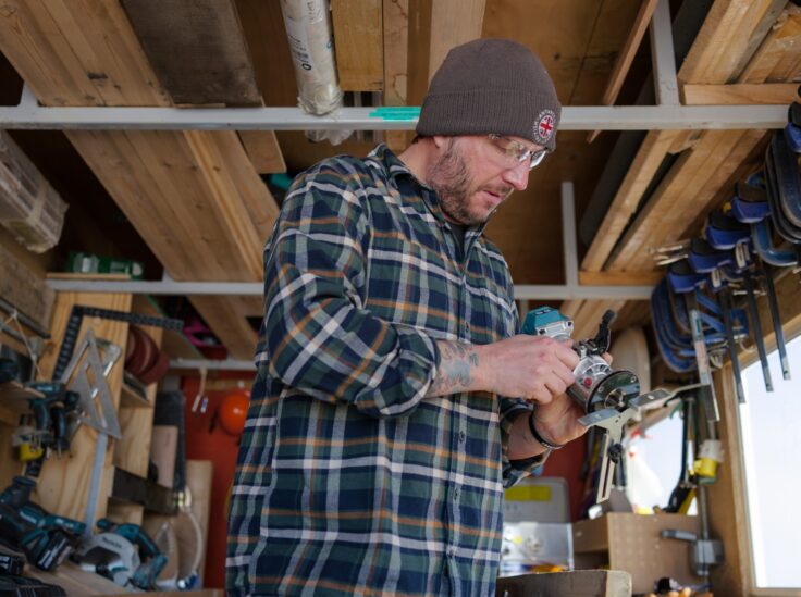 A man standing in a carpentry shed.