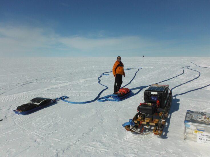 A group of people riding skis on top of a snow covered slope