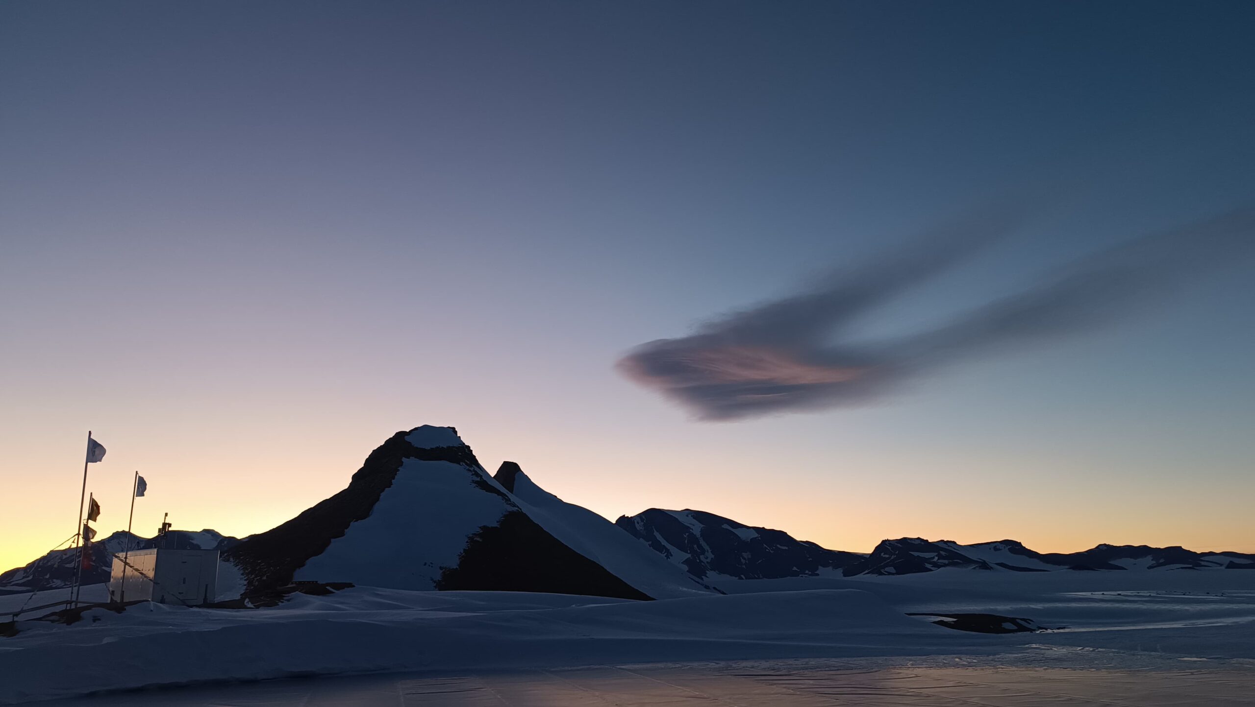 A sunset over a snow covered mountain