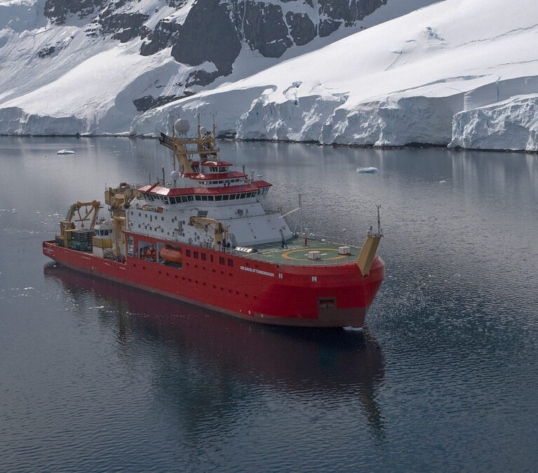RRS Sir David Attenborough sailing past an ice shelf