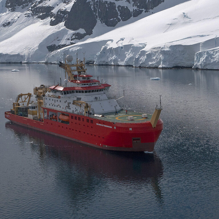 RRS Sir David Attenborough sailing past an ice shelf