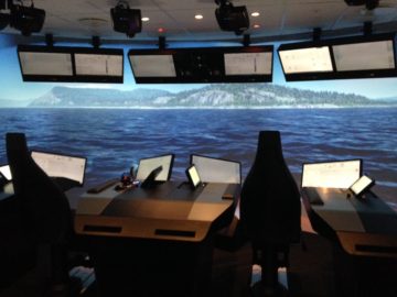 A group of people sitting at a table in front of water.