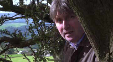 Simon armitage wearing a suit and tie.