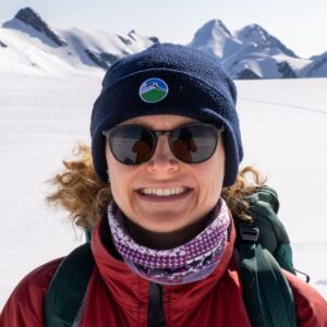 A person wearing a hat and smiling at the camera