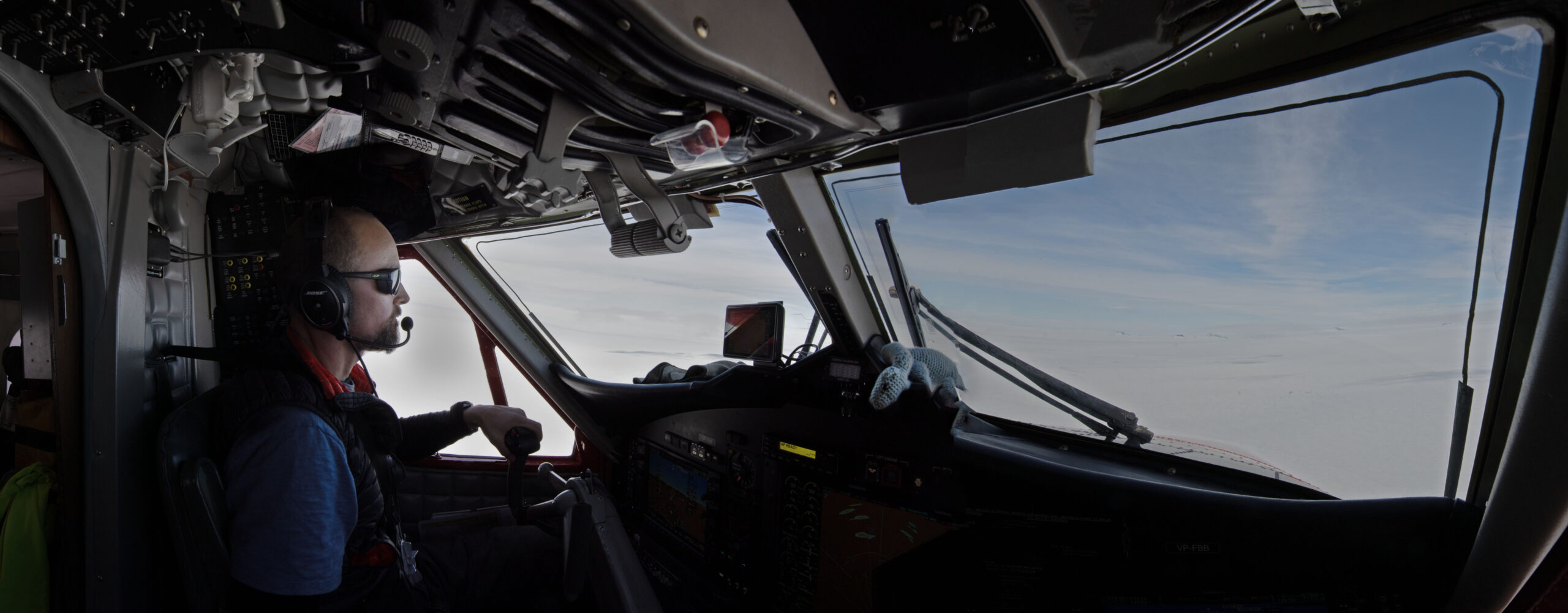 BAS pilot at the controls of a ski equipped Twin Otter Aircraft during a flight to Rothera Research Station
