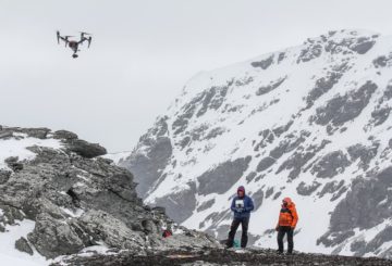 A man standing on top of a snow covered mountain