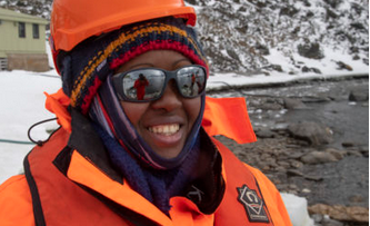 A person wearing a hard hat and sunglasses posing for the camera
