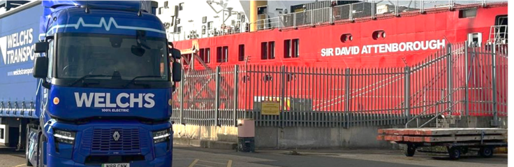 A HGV parked next to the RRS Sir David Attenborough polar research ship docked at Harwich.
